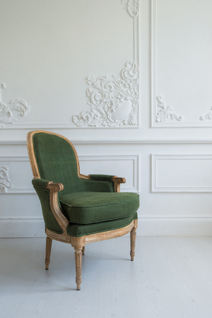 One classic armchair against a white wall and floor. Copy space.の写真素材