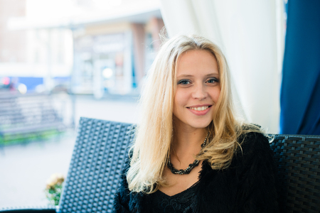 Young attractive girl smiling at outdoors restaurant.の写真素材