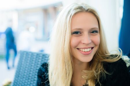 Close up portrait view of an attractive young professional business woman sitting at a cafe terrace shop, outdoorsの写真素材