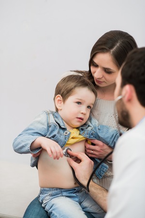 Pediatrician doctor examining boy lungs in focus.の写真素材