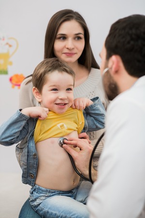 Pediatrician doctor examining boy lungs in focus.の写真素材
