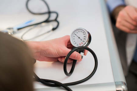 A doctor is measuring blood pressure with a tonometer.の写真素材