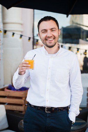 Young Man Holding Glass Of Orange Juice, Outdoors.の写真素材