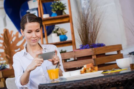 Woman hands taking food photo by mobile phone. Food photography. Delicious foodの写真素材