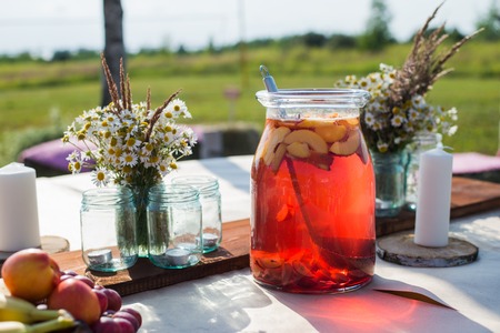 Fresh compote, fruits and flowers on wooden table closeup. Selective focus. Beutiful decoration in boho styleの写真素材