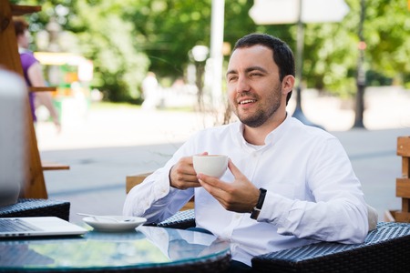 Confident successful businessman in suit enjoying a cup of coffee while having work break lunch in modern restaurant,young intelligent man or entrepreneur relaxing in outdoors cafe looking pensive.の写真素材