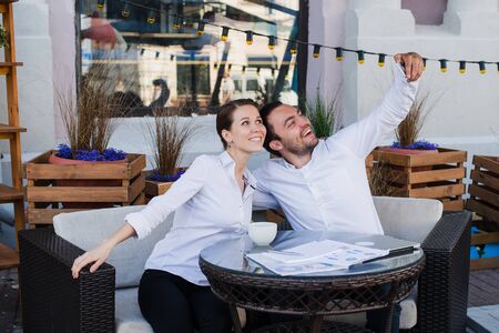 Happy business couple taking selfie at outdoor restaurant.の写真素材