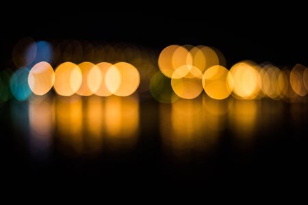 Beautiful blurred city lights with bokeh effect reflected on water background.の写真素材