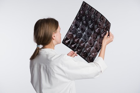 A female doctor examining an x-ray picture, back-view.の写真素材