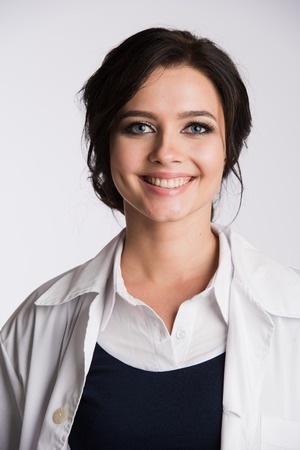Close portrait of a beautiful nurse smiling over white background.の写真素材