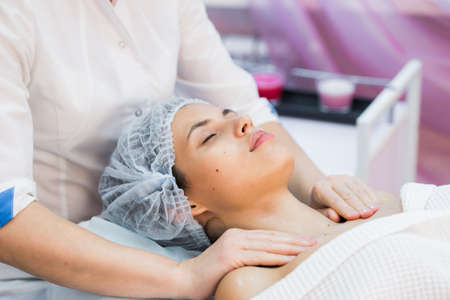 Young woman enjoying facial at spa salon.の写真素材
