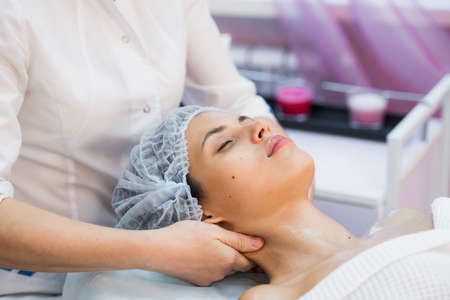 Young woman enjoying facial at spa salon.の写真素材