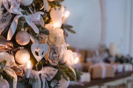 Christmas angel and balls on a tree branch with a lights decorated as candles.