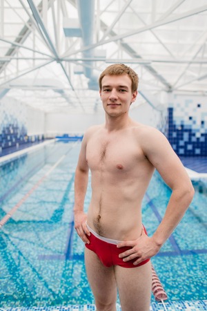 Portrait of swimmer standing with arms crossed at the leisure center.の写真素材