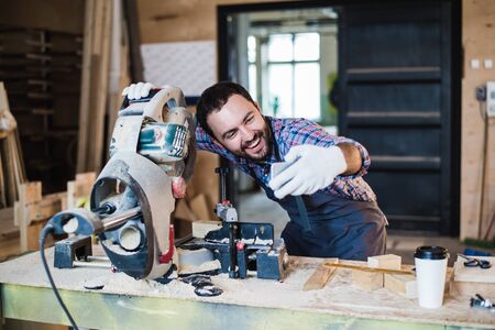 Carpenter taking a selfie with miter saw at his work place.の写真素材