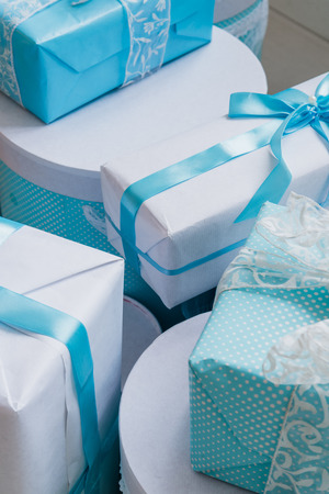 Christmas gift box with blue bow and bokeh lights on wooden surface.の写真素材