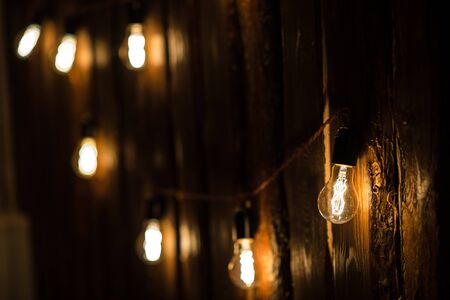 Vintage incandescent Edison type bulbs on wooden wall.の写真素材