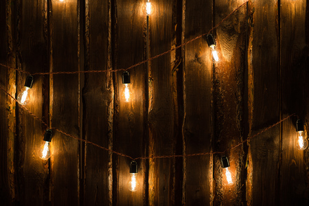 Designer light bulbs on dark wooden background.