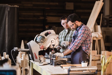 Inspector and carpenter discuss the process of making wood products for furniture.の写真素材