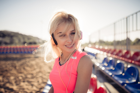 Smiling beach volleyball female player portrait with earphonesの写真素材