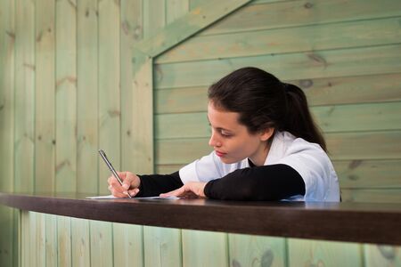The female doctor sits at a table having closed eyes for fatigue.の写真素材