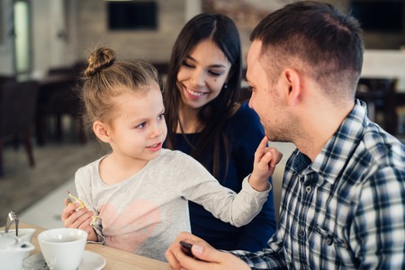 Happy family Enjoying tea In Cafe Together.