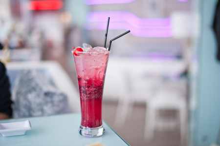 Glass of cherry soda with ice at cafe indoors.の写真素材