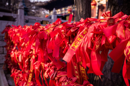 Chinese red ribbons on a fence in Buddhist temple.の写真素材