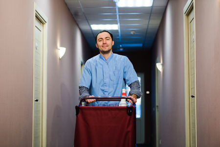 Young handsome pushing cleaning cart - a series of HOTEL images.の写真素材