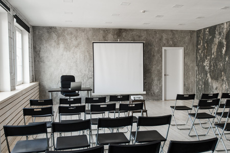 Empty modern classroom with black chairs projector screenの写真素材