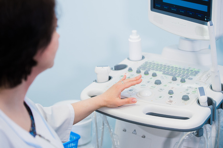 Happy mature female doctor using ultrasound scanner. Echography machineの写真素材