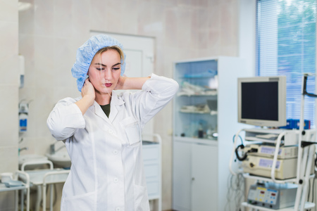 Young doctor during preparation for operation. Assistant of surgeon wearing medical cap in operation...