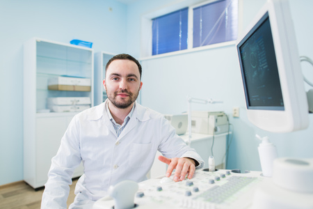 Male doctor with ultrasonic equipment during ultrasound medical examinationの写真素材