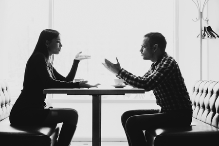 Man and woman in discussions in the restaurantの写真素材