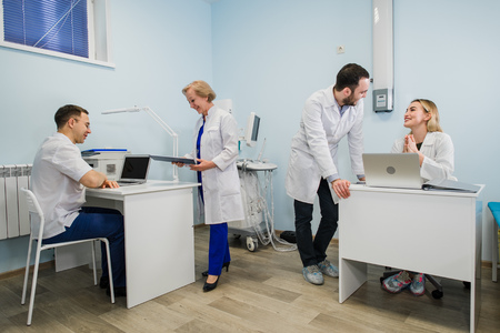 Group Of Doctors Involved In Serious Discussion With Medical Records