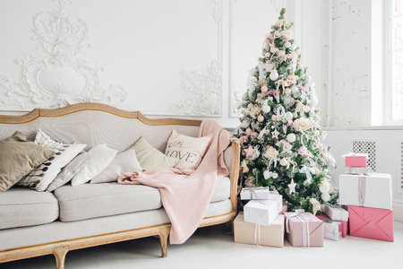 Christmas tree with a white sofa in a white room.