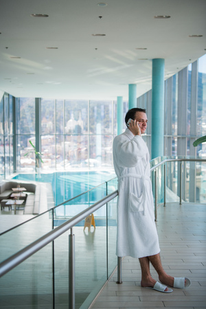 Man use the cellphone at luxury hotel spa in the near the swimming poolの写真素材