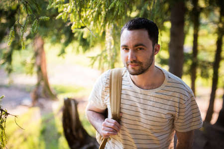 Smiling happy handsome man with beard in forest, mountains, park. Traveler Man relaxing . Travel Lifestyle hiking concept summer vacations outdoor. Bearded man.の写真素材
