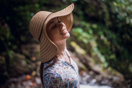 Portrait of young attractive female smiling in a jungle forest, summer vacation. Young woman enjoying fresh air in the national park.の写真素材