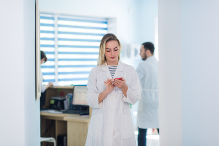 Portrait of female doctor with interns in background