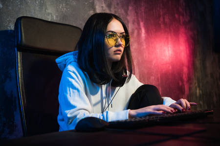 young attractive teen woman eyeglasses on looking dark and dangerous hacking computer system on...
