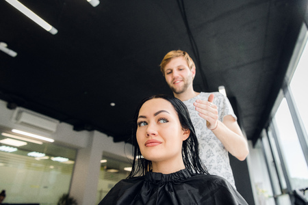 Professional hairdresser discussing female customer preferences in barbershop, choosing new hairdoの写真素材