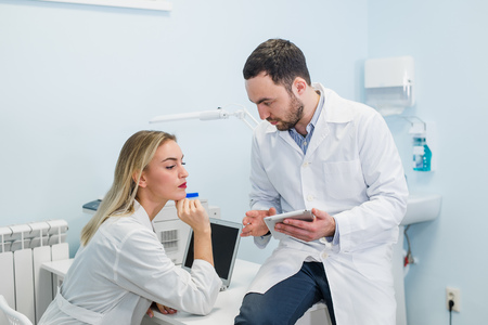 Doctor and nurse student working with a tablet isolated on a white backgroundの写真素材