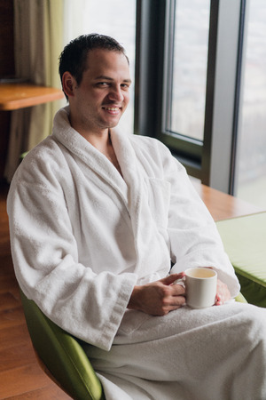 Morning portrait of handsome young man with cup of coffeeの写真素材