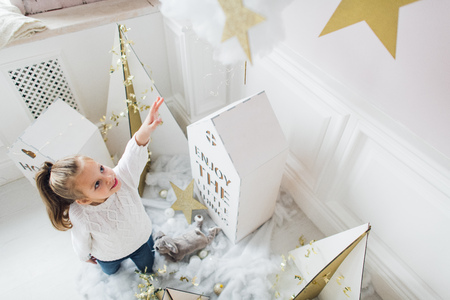 Little girl with house models and stars decorationの写真素材
