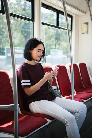 Young teenage girl using her cell phone in public transportationの写真素材