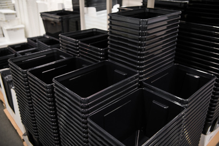 Black plastic box containers in row at storeの写真素材