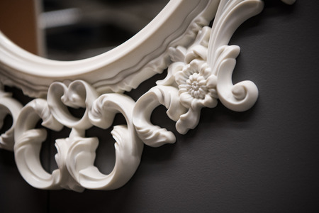 Expensive interior. Stucco elements on a mirror. White patterned. Mouldings element from gypsum or plastic. Roccoco style.の写真素材