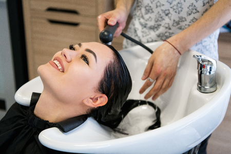 Hairdresser salon. Woman sit during hair wash at salon.の写真素材