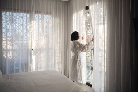 Morning of beautiful young woman near windowの写真素材